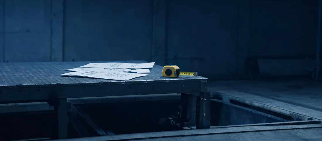 Hydraulic dock lift specification notes on a warehouse bench